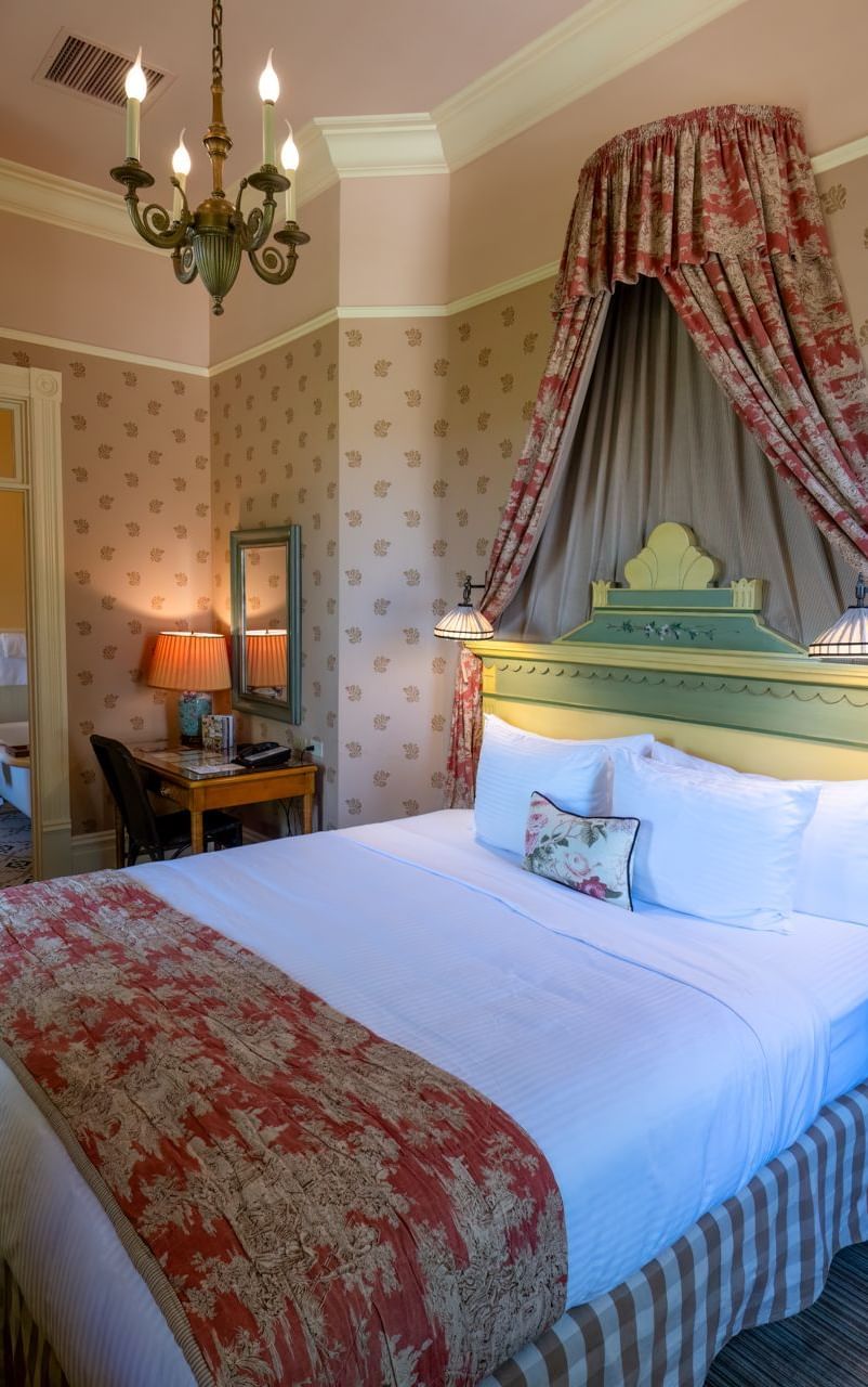 Bedroom of an accommodation, furnished with plush bedding, at Tallman Hotel.
