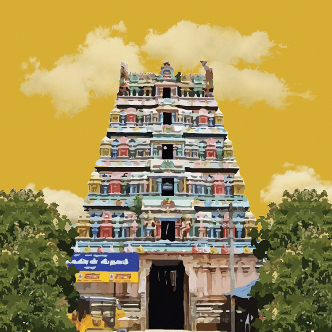 Colourful gopuram of a temple framed by lush greenery and a golden sky.