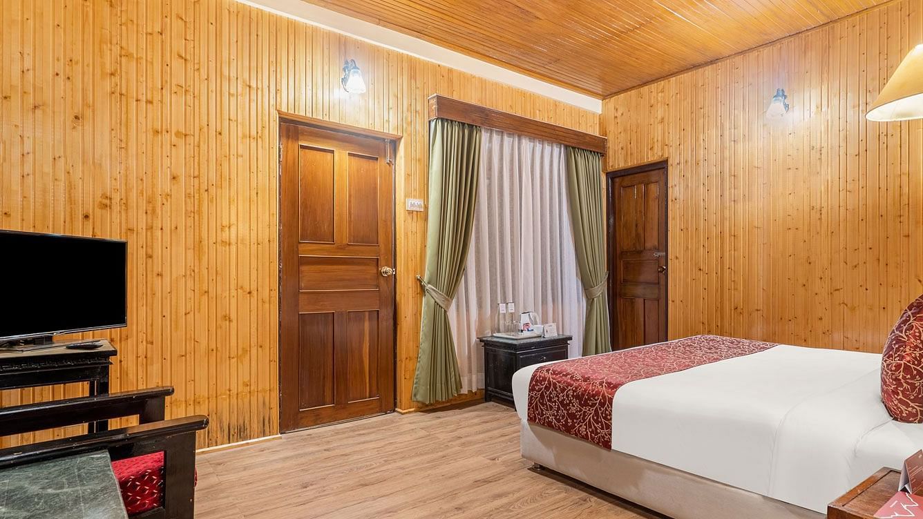 Image of a room with bed and a television in the corner at at Summit Tashi Ghang Heritage Resort, Pelling