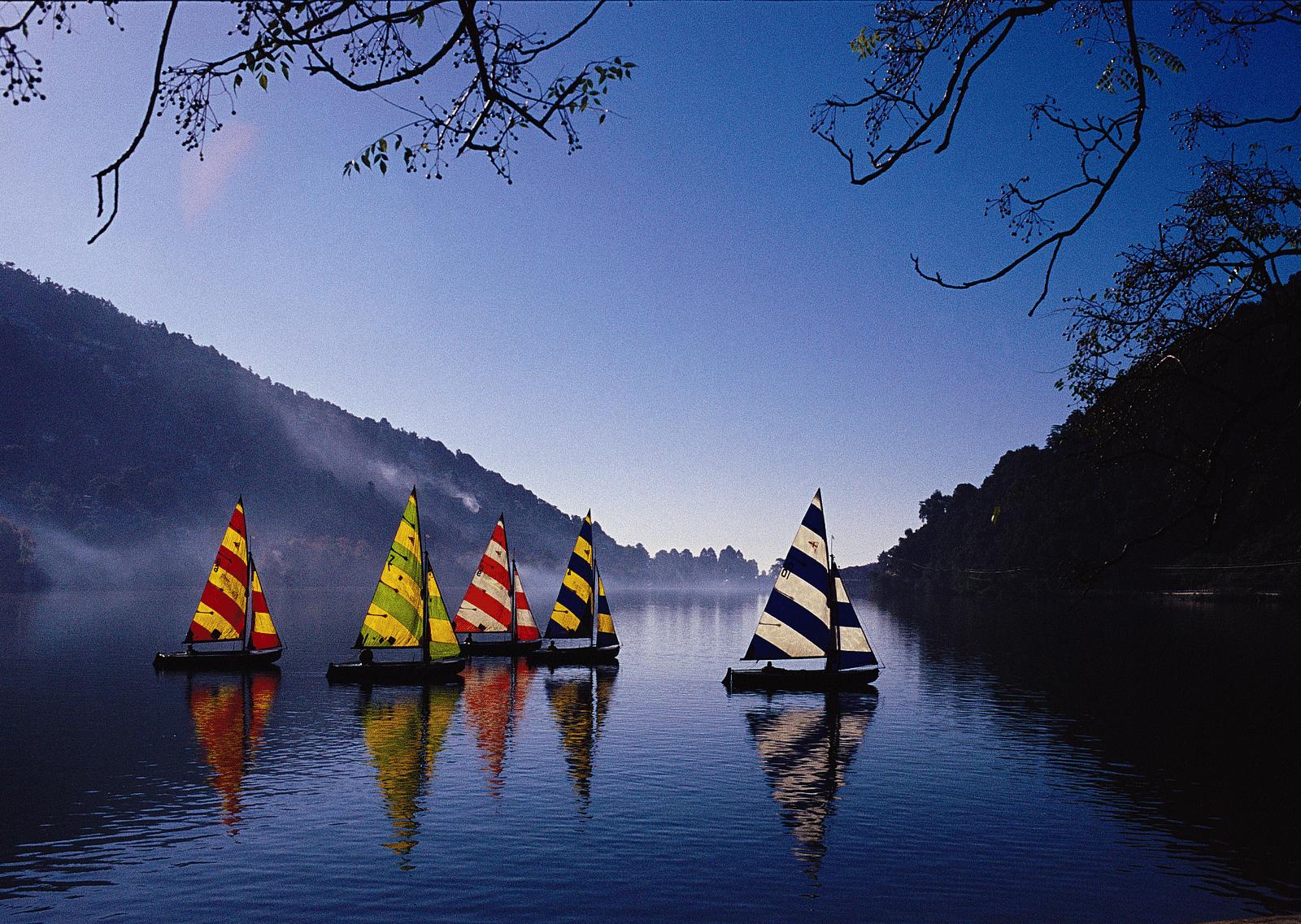 Colorful paddleboats on a lake at sunset.