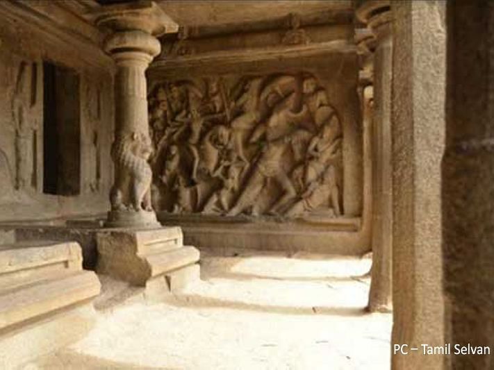 An image showing pillar with lion engraved on it and a wall with more detailed engravings in the background.