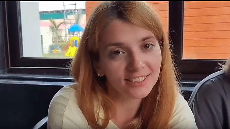 an image of a woman with auburn hair and a window in the background