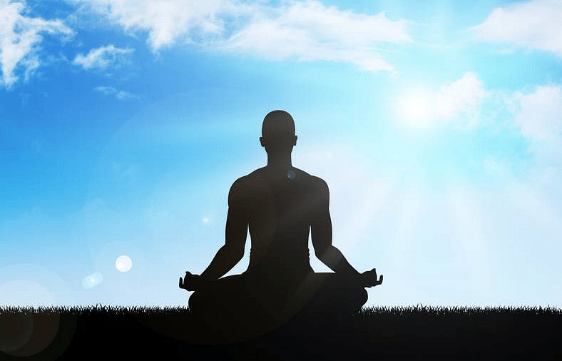 A close image of a person meditating , positioned in the centre.
