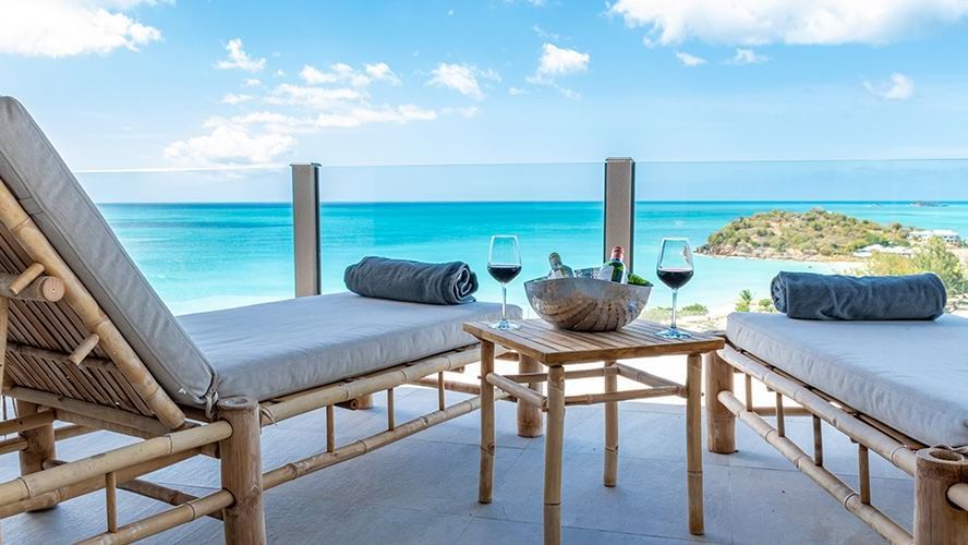 Oceanfront deck with sun loungers at Tamarind Hills Resort and Villas Antigua, offering breathtaking ocean views.
