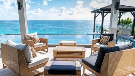Outdoor seating area with ocean view and cushioned chairs at Tamarind Hills Resort and Villas - Antigua.