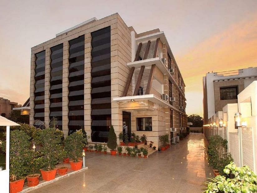 Exterior view of Five Elements Hotels The Claire, Gurugram, showcasing the modern facade and entrance area at sunset