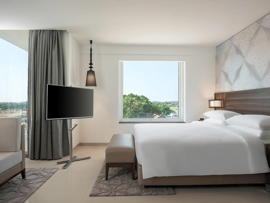 Suite Room with a plush bed and television at The Residency Towers Rameswaram