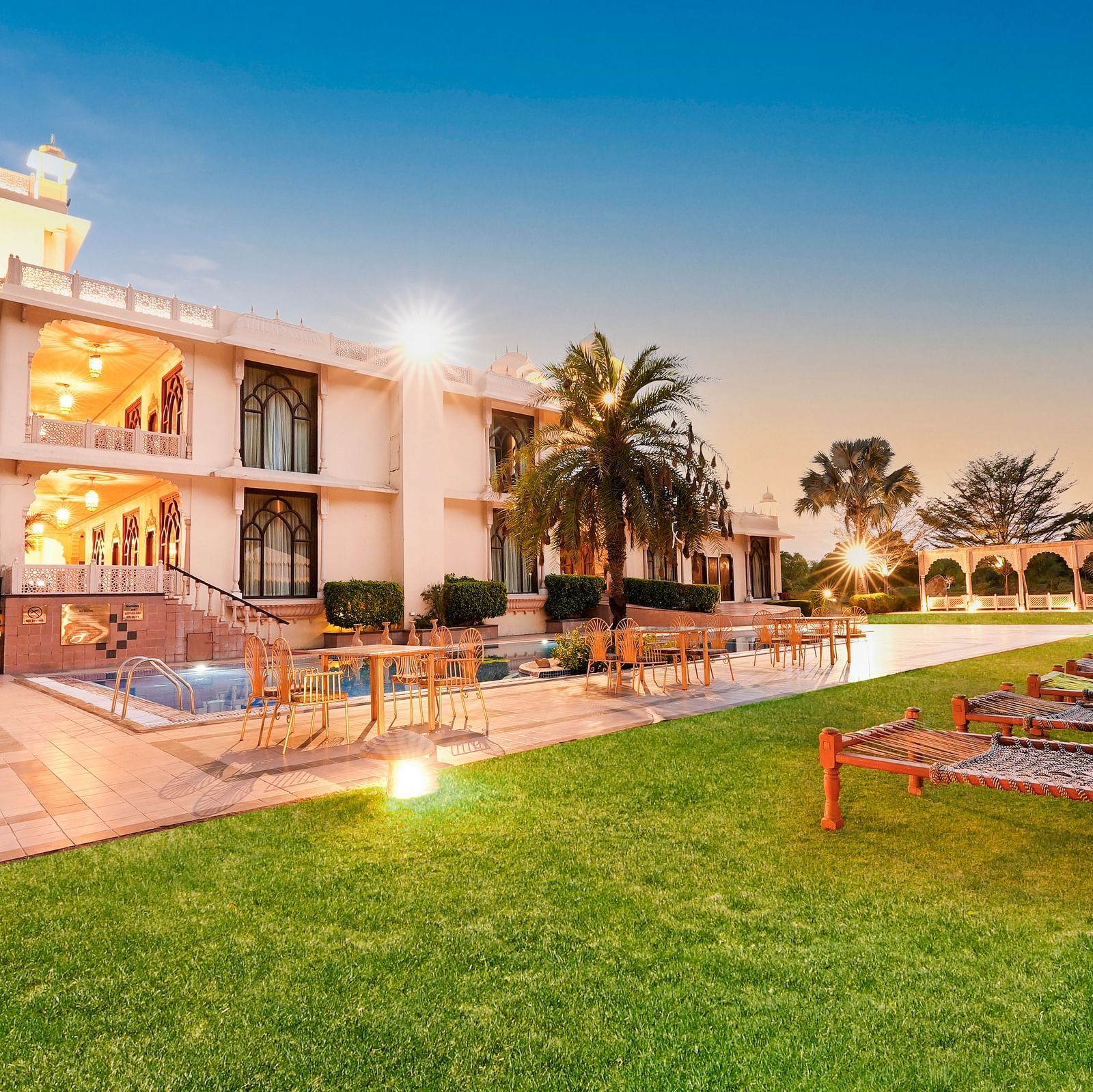 Lawn area with a sit out in front of the building in the night - Rajasthali Resort & Spa, Jaipur.