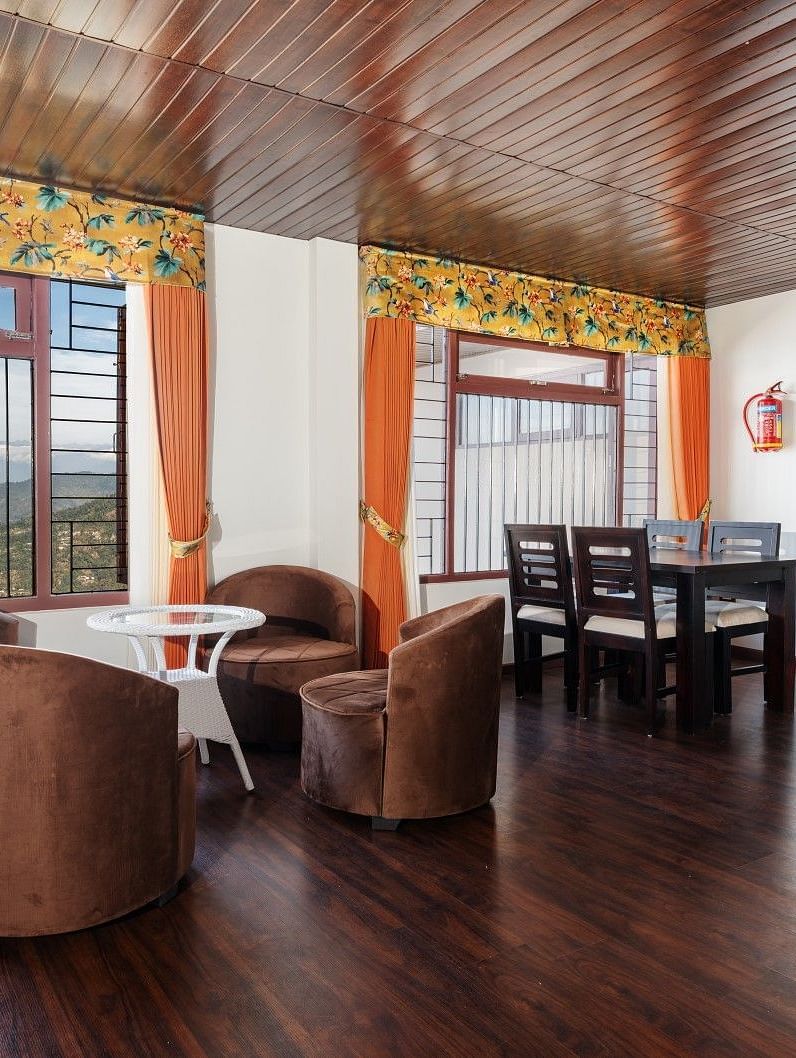 Image of a seating area with chairs and tables at Summit Sherpa Mountain Hotel & Spa, Kalimpong