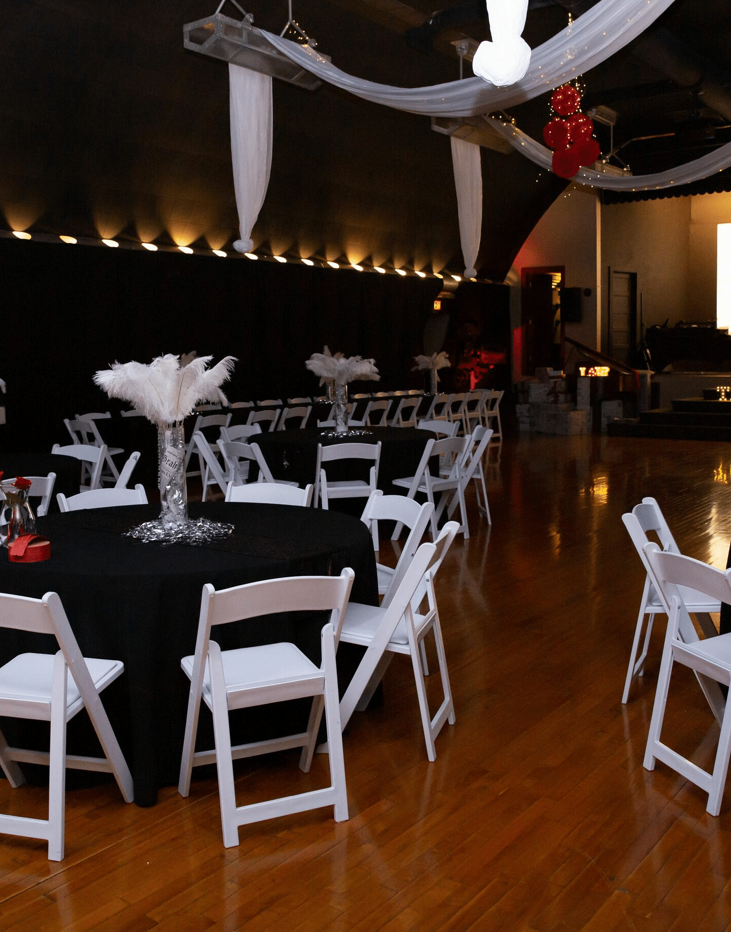 full view image of the Tin Can Theater featuring the round tables and the folding chairs with a projector screen at the far end - Historic Tapoco Lodge
