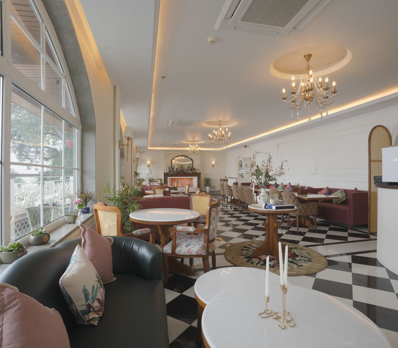 Stylish cafe interior with natural lighting, white tables, and cushioned seating - Mayfair Cafe & Suites, Dalhousie