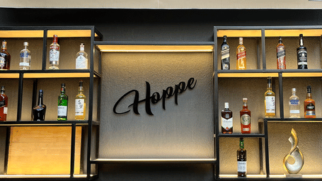 The bar area at Nemesia is visible with shelving, a counter, and the word Hoppe.