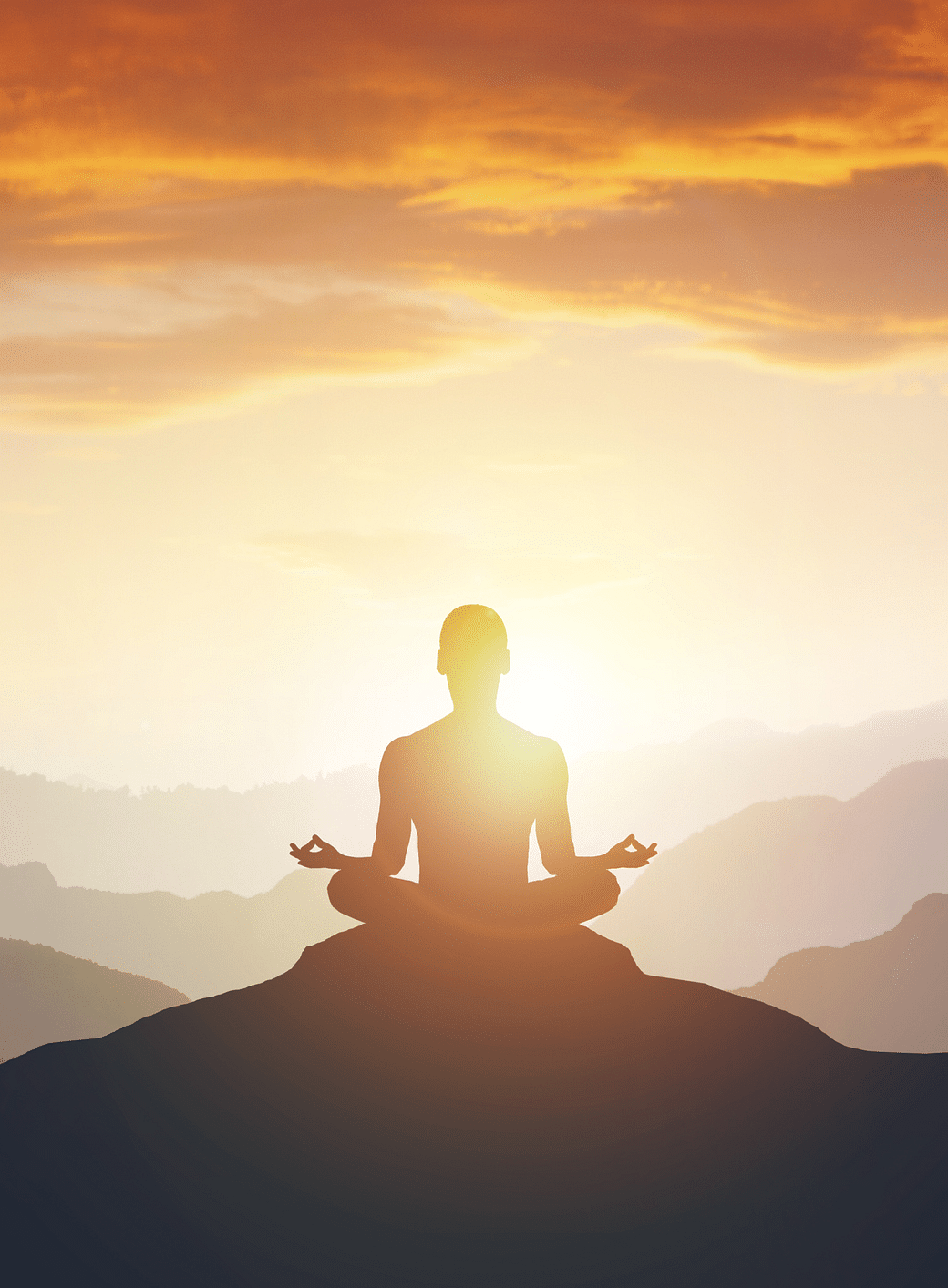 a silhouette of a person doing meditation on a hilltop with sun rays shining in the background