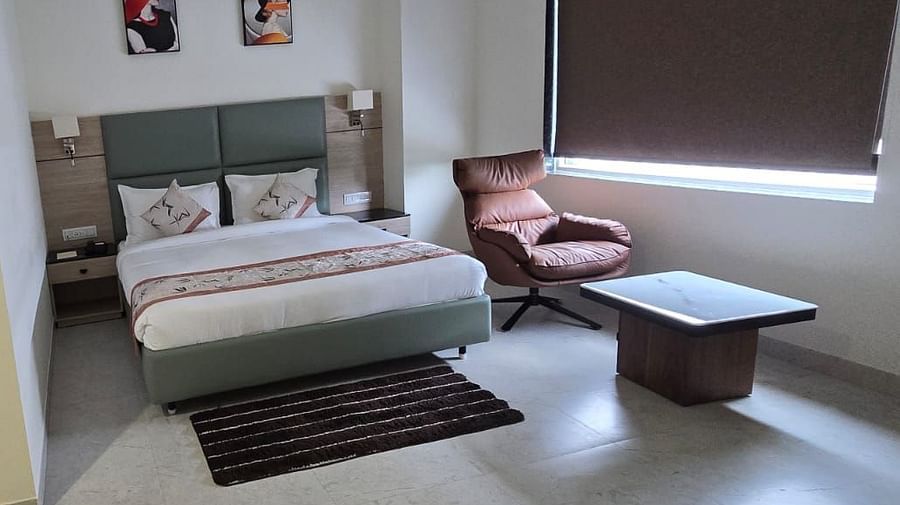 Premium Room in Clarks Inn Express, Firozabad, featuring a double bed, lounge chair and  a glimpse of the washroom.