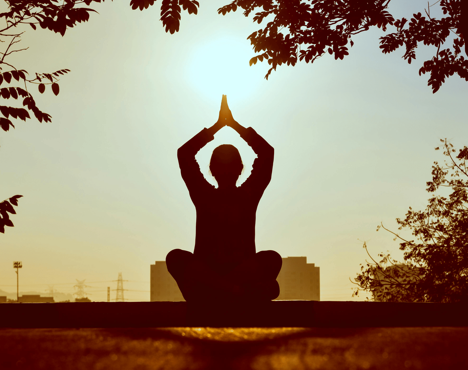 Silhouette of a person practicing yoga at sunset.