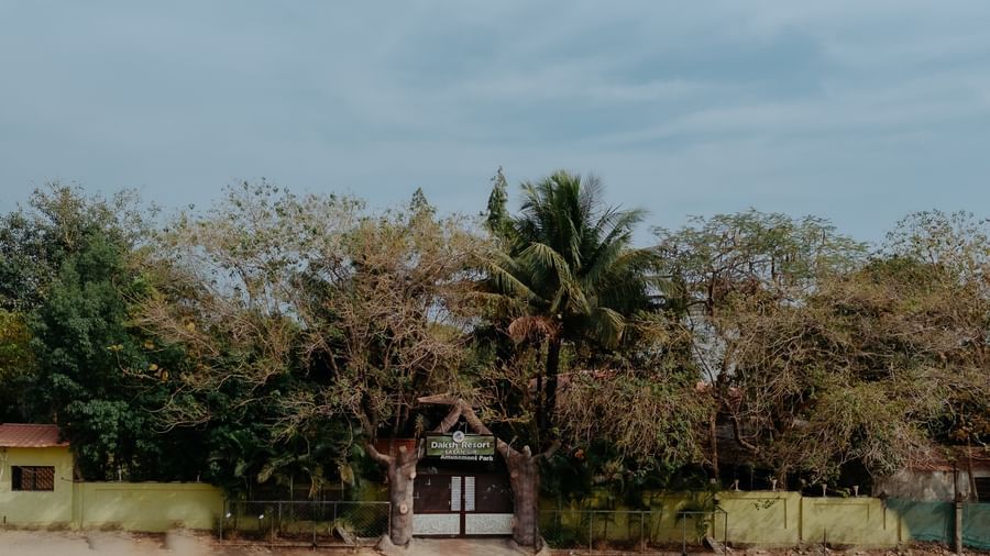 A view of the entrance to Daksh Resort & Amusement Park, Sasan Gir, covered with greenery.