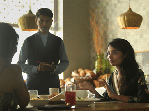 two women dining at our cafe and a waiter standing beside them at The Residency Towers Rameswaram