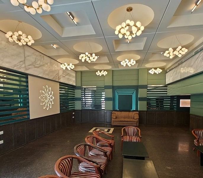 Full view shot of the Boardroom at Hotel Gold, Panipat with several brown coloured leather arm chairs arranged facing towards each other.