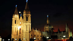 Illuminated Gothic-style church captured at night with glowing lights.