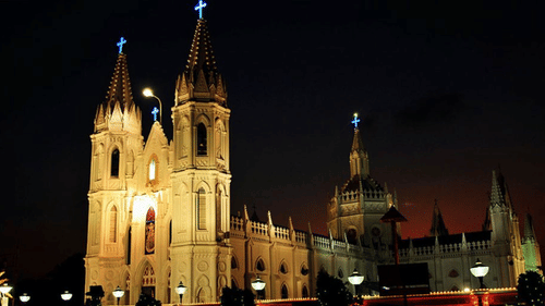 Illuminated Gothic-style church captured at night with glowing lights.