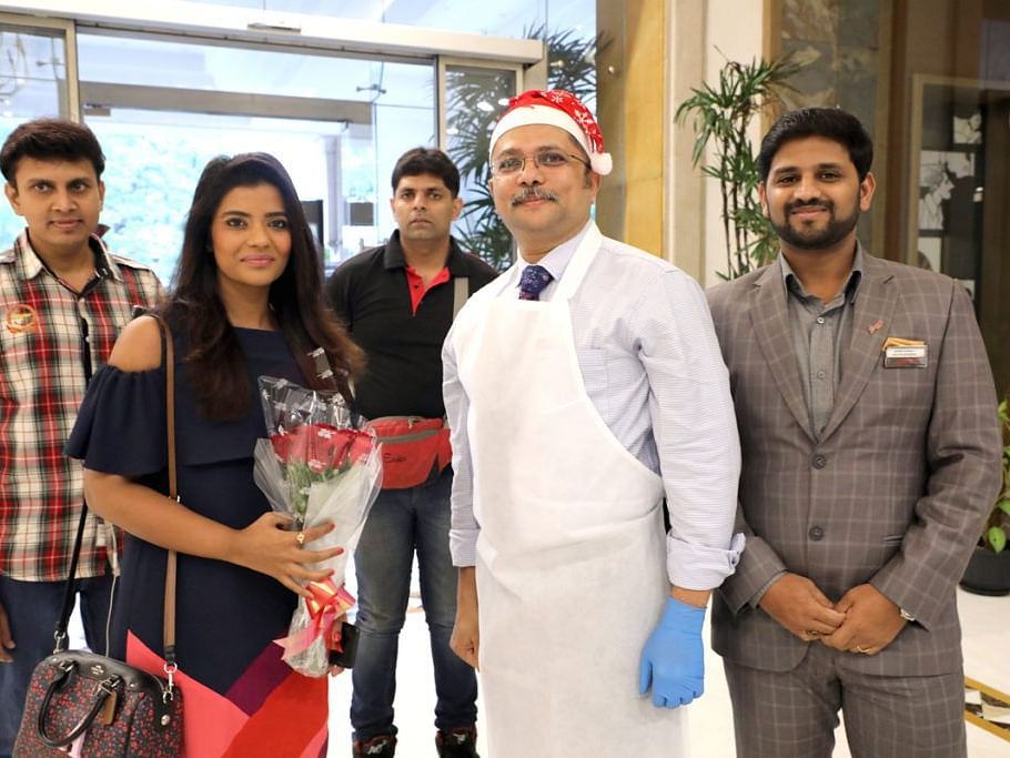 Hotel staff welcoming a guest with a rose bouquet.