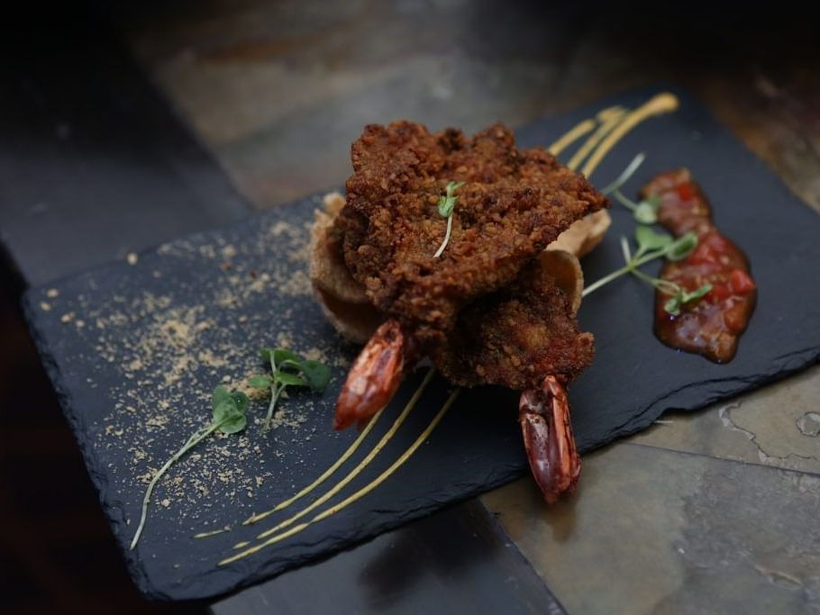 Plated gourmet dish featuring grilled meat and vegetables with an artistic presentation.