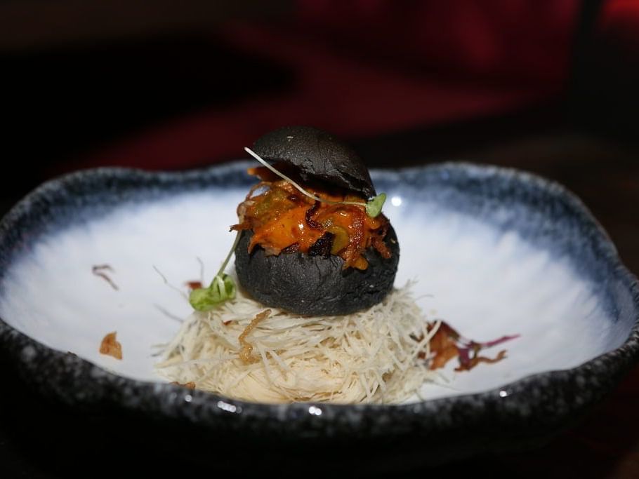 Elegant dessert plated with artistic presentation on a dark background.
