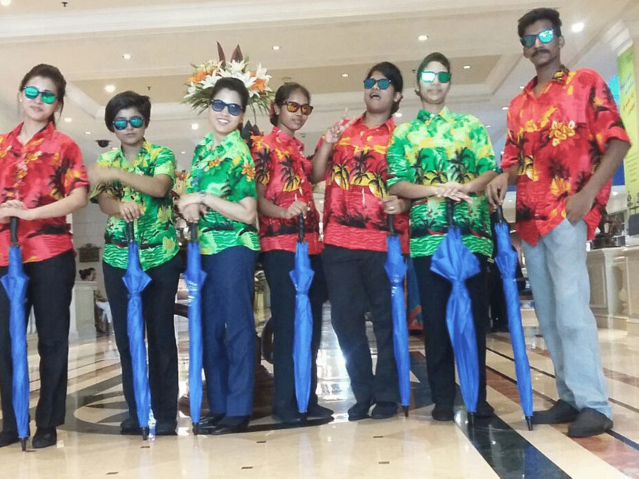 Hotel staff dressed in colourful uniforms posing in a lobby area.