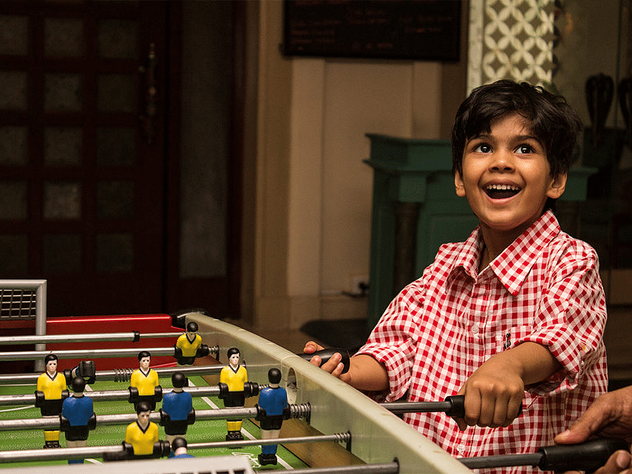 Happy child playing foosball in a recreational area.