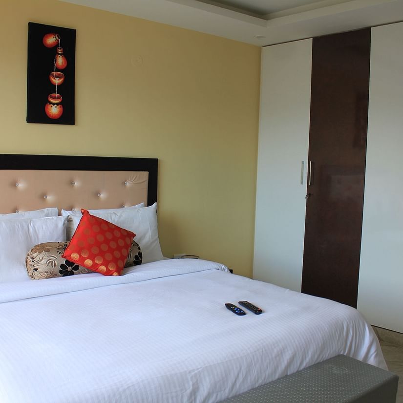 A king size bed with bedding in the deluxe room - Silverpine Apartments & Homestay, Mehli