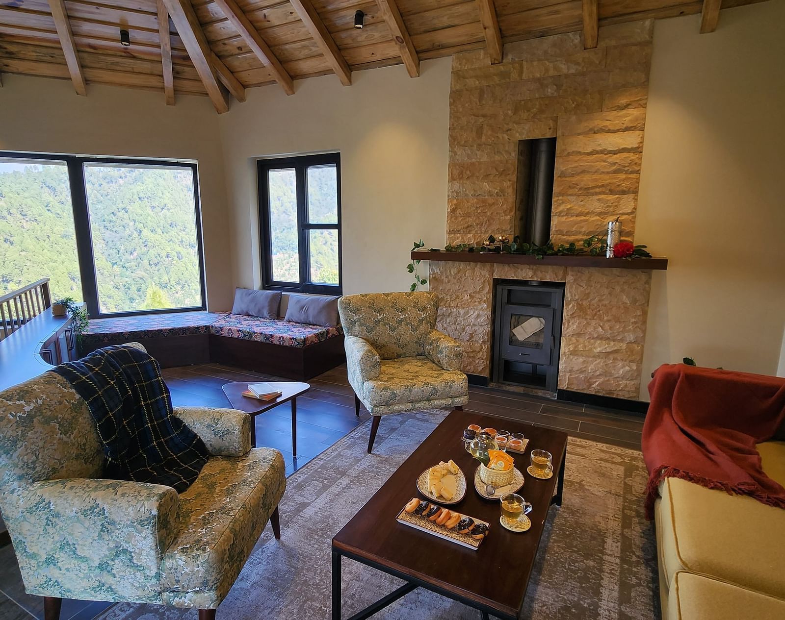 Cosy living room with a fireplace and armchairs arranged around the table at The Chamomile Estate.