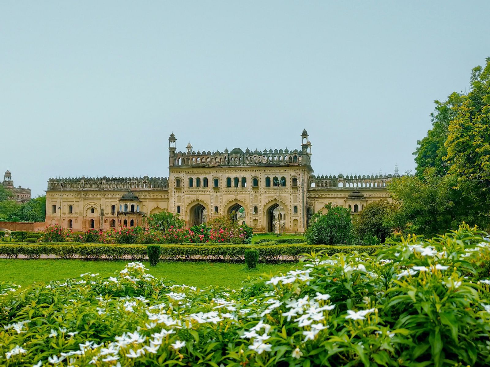 view of Bada Imambara in Lucknow from a garden with flowers and trees