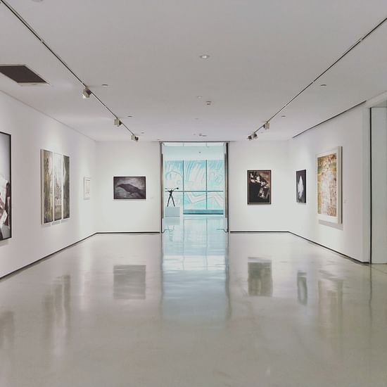 An overview of a museum with painting hung on all the walls