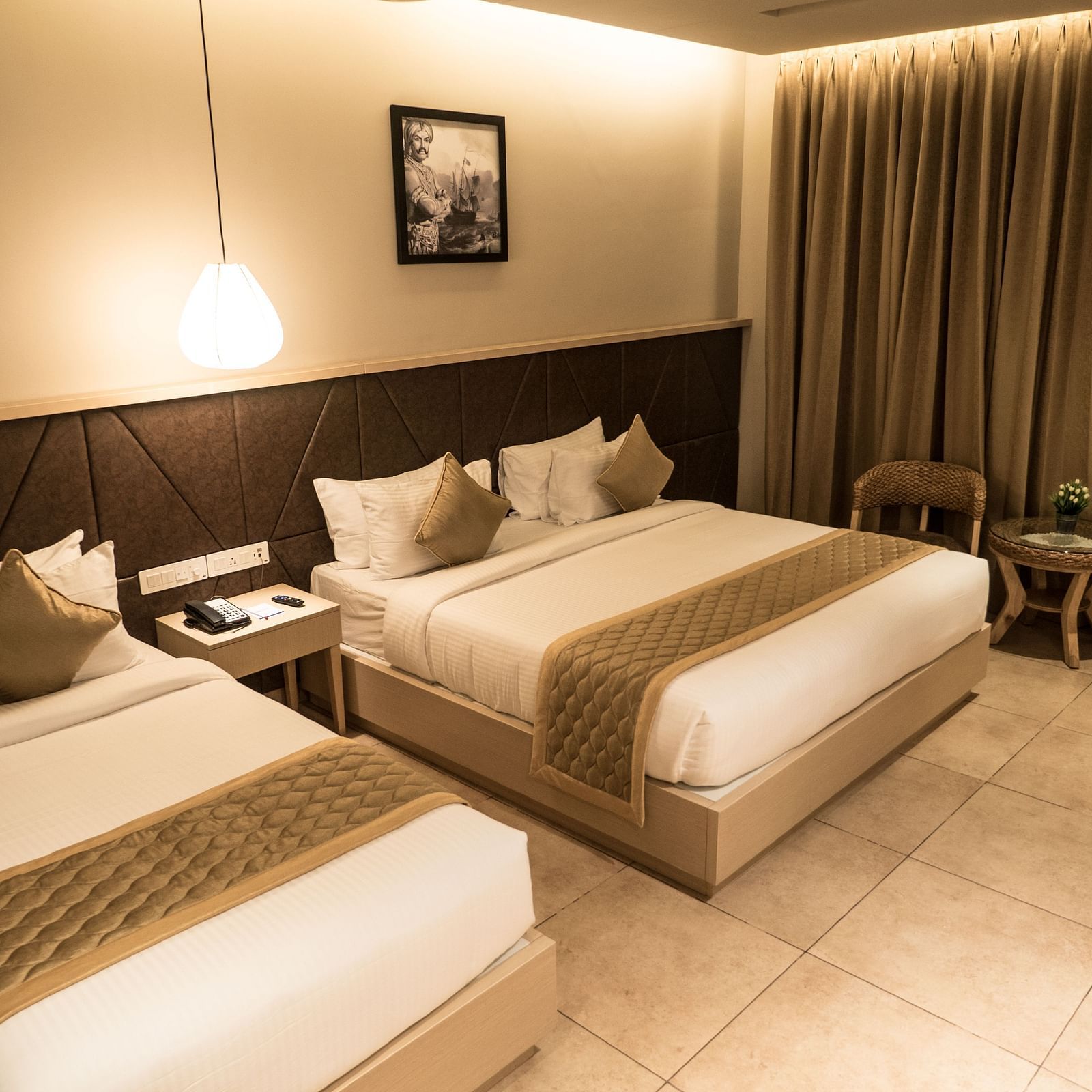 view of a king size bed and a single bed at Executive Tripple Room at Cholaa Dynasty, Kumbakonam
