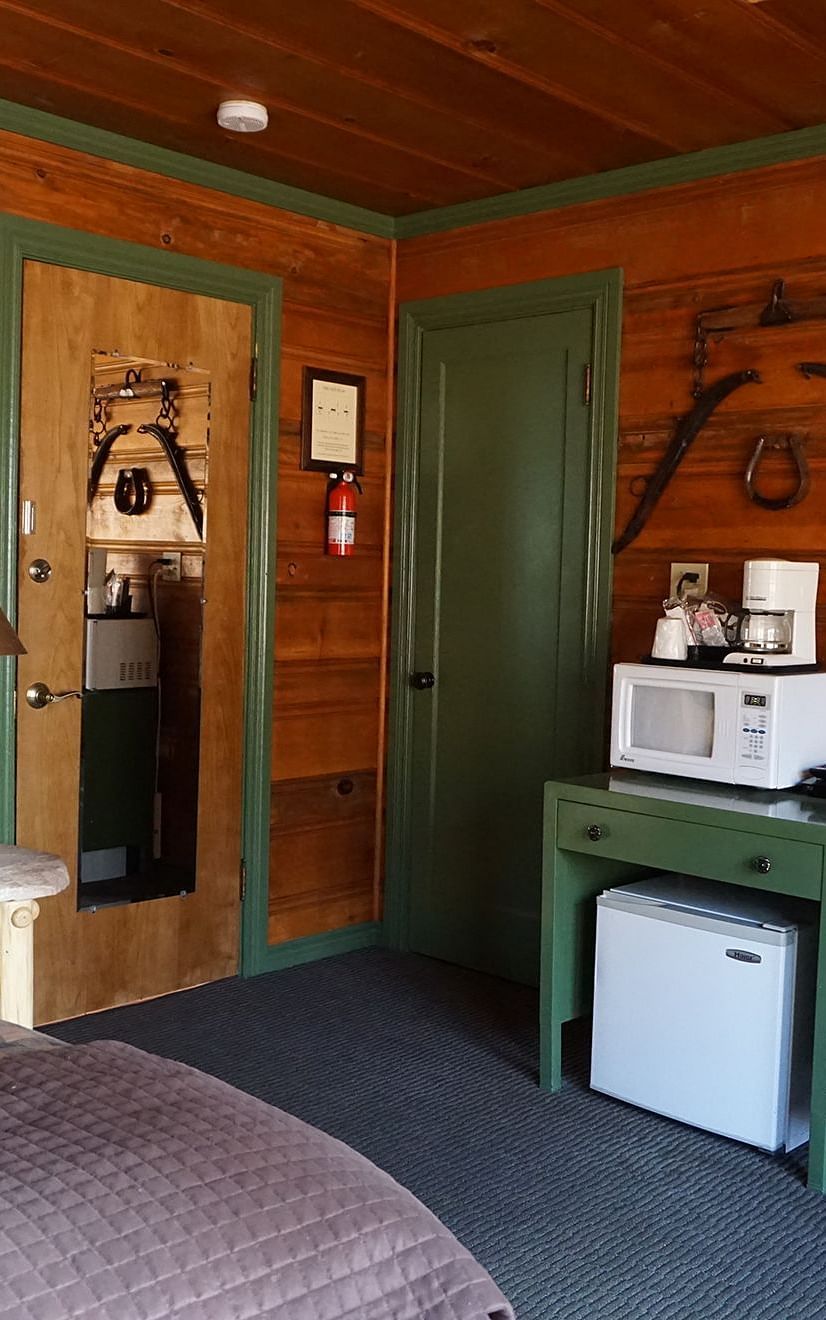A room at Shaver Lake Village Hotel with a double bed, a cabinet and wooden panelling throughout.