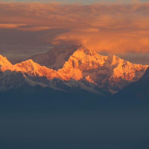 Snow-covered mountain peaks glowing under the evening light.