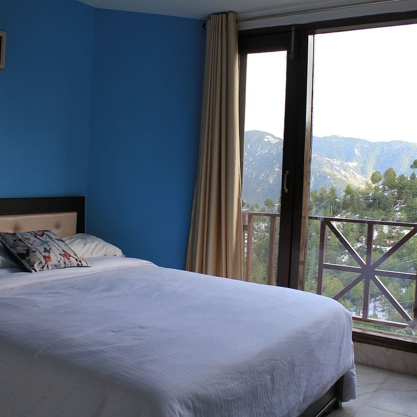 A king size bed placed beside the attached balcony - Silverpine Apartments & Homestay, Mehli