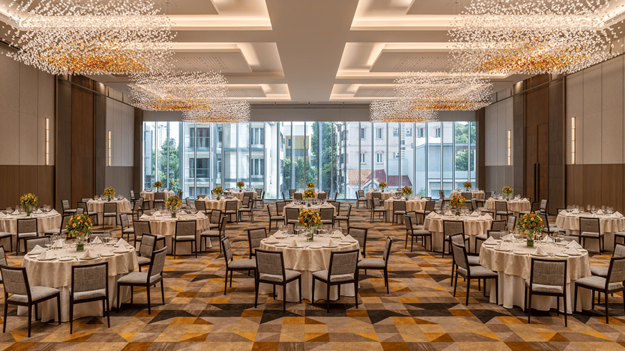 The spacious Ballroom 1 set with round banquet tables, modern chandelier lighting, and large windows at The Residency Towers Chennai.