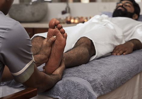 Person receiving a foot massage, close-up shot, spa treatment - Shreyas Retreat