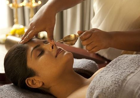 A person receiving a treatment, close-up, spa setting - Shreyas Retreat