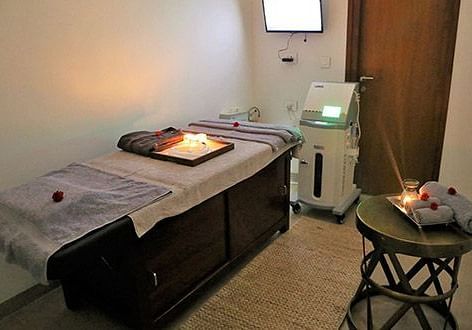 A massage table in a dimly lit room, indoor setting - Shreyas Retreat