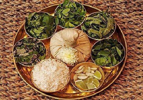 A golden tray with small bowls containing various ingredients, arranged on a textured surface.