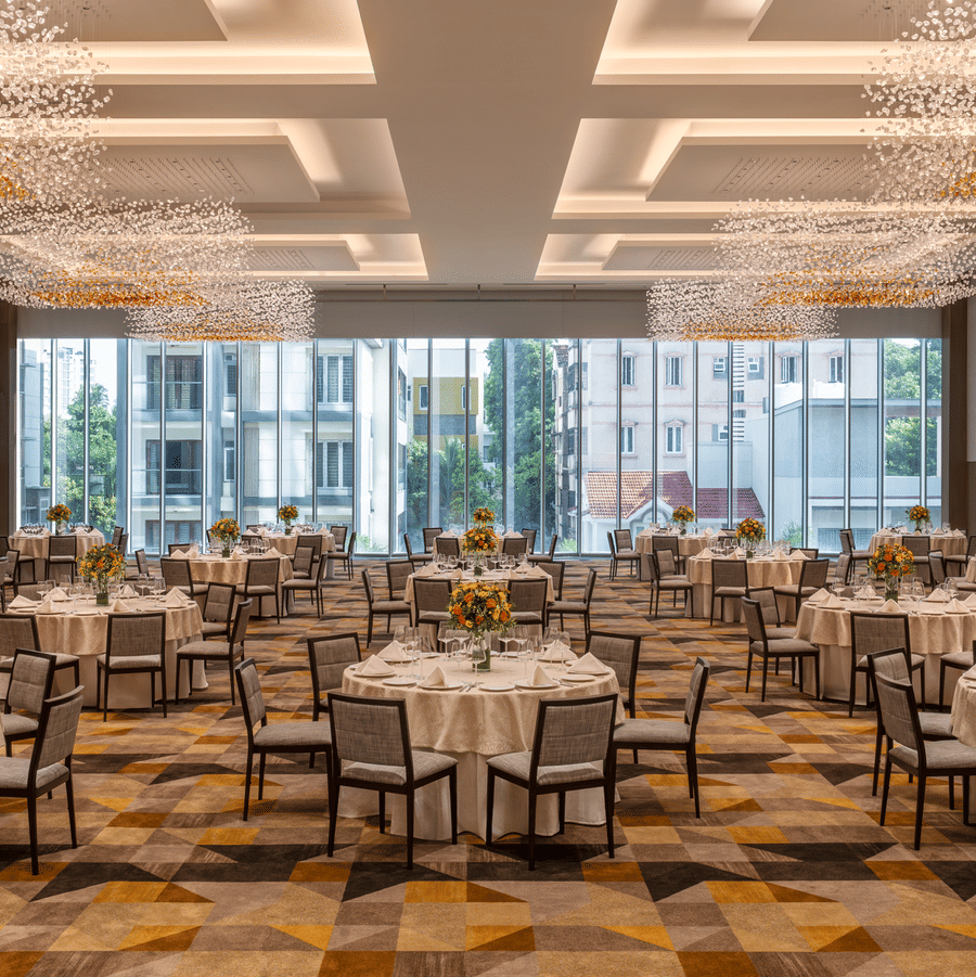 The spacious Ballroom 1 set with round banquet tables, modern chandelier lighting, and large windows at The Residency Towers Chennai.