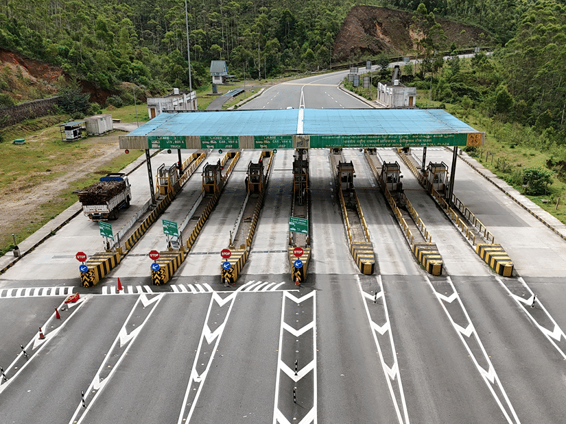 A toll booth on the way to Kabini from Bangalore with its multiple lanes and blue shade surrounded by lush greenery.