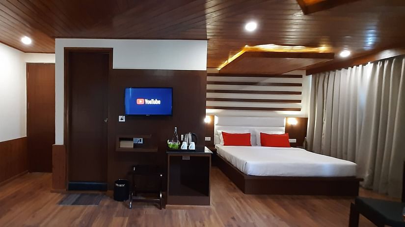 Front-view of family suite at Mastiff Xanadu in Manali with a bed, TV and a work desk