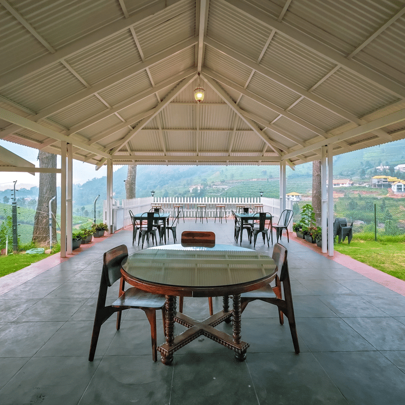 Seating arrangement inside a gazebo with manicured garden on either side - Ibex Stays & Trails, Coonoor (Leewood).