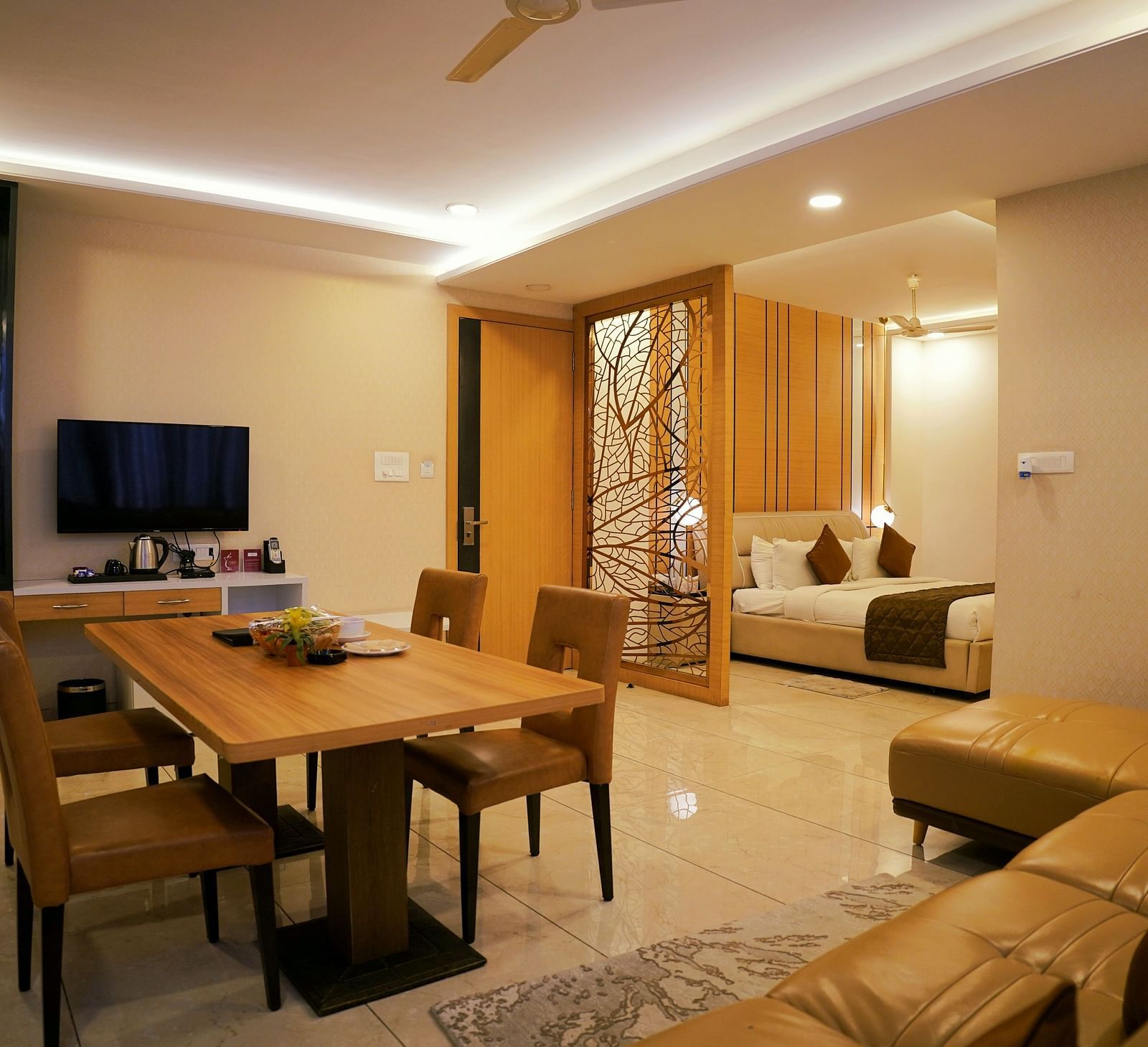 A modern living space featuring a dining area and a view into the bedroom - TGI Insignia, Bhopal