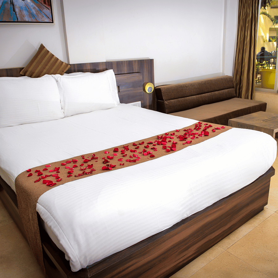 A close up view of the bed in Regent Room with its sofa and glass doors that lead to the balcony.