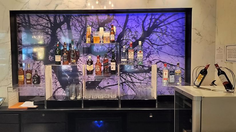 Lounge with wall-mounted TV, console, and vibrant backlit wall art behind the seating area.