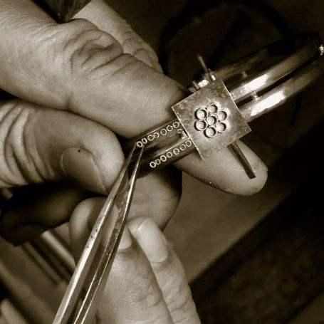 Hands crafting intricate geometric pattern on kadaga.